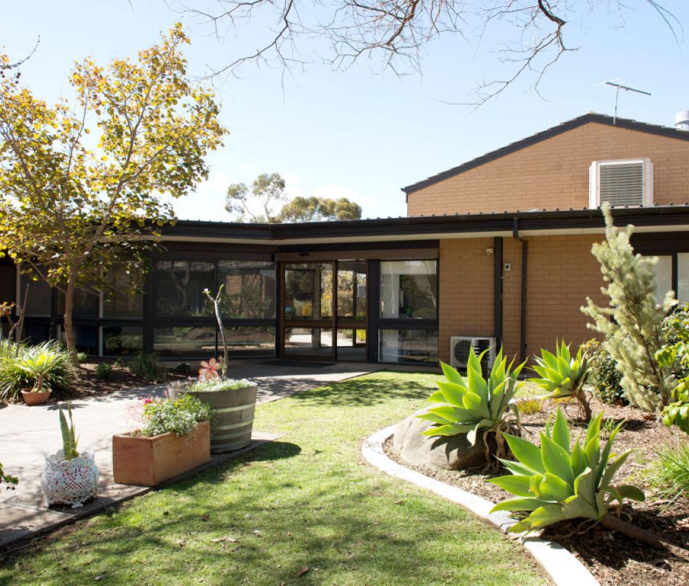 Courtyard at Eldercare Acacia Court with green trees and shrubbery.