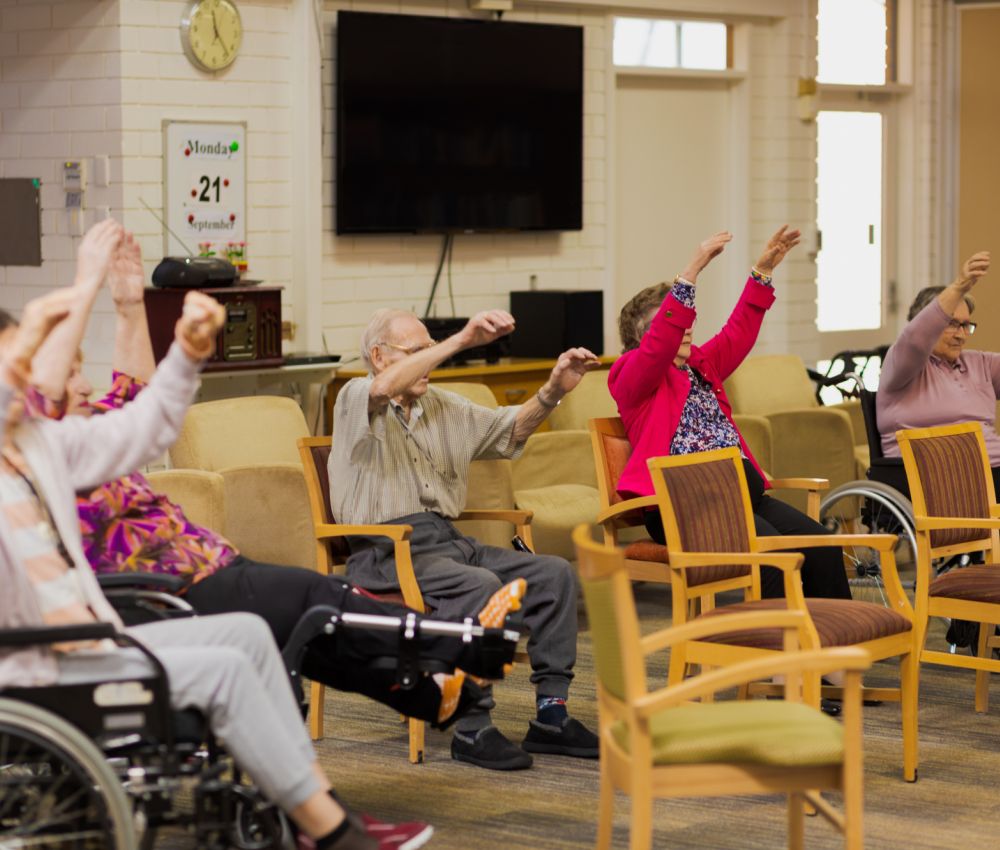 A group of Eldercare residents participate in chair yoga.