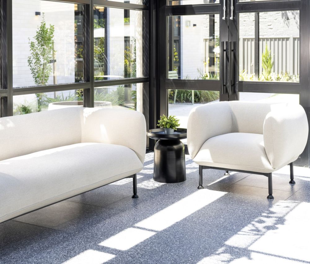 Stylish conservatory patio with white furniture and vibrant plants, offering a contemporary and inviting atmosphere.