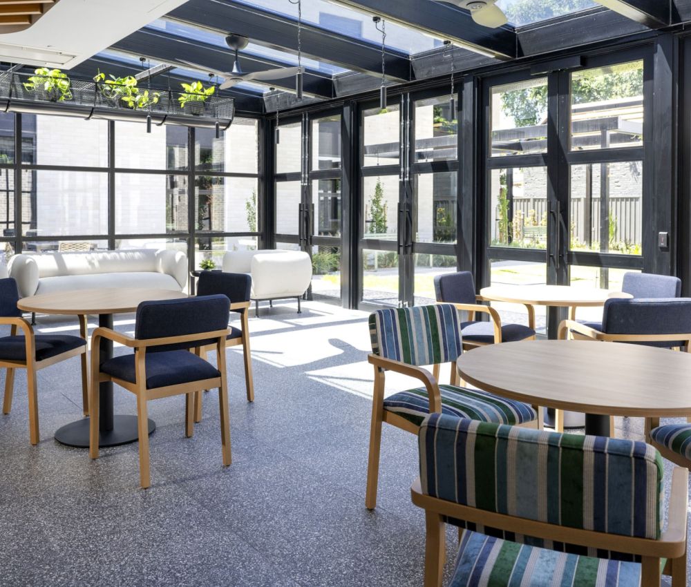 Stylish conservatory patio with white furniture and vibrant plants, offering a contemporary and inviting atmosphere.