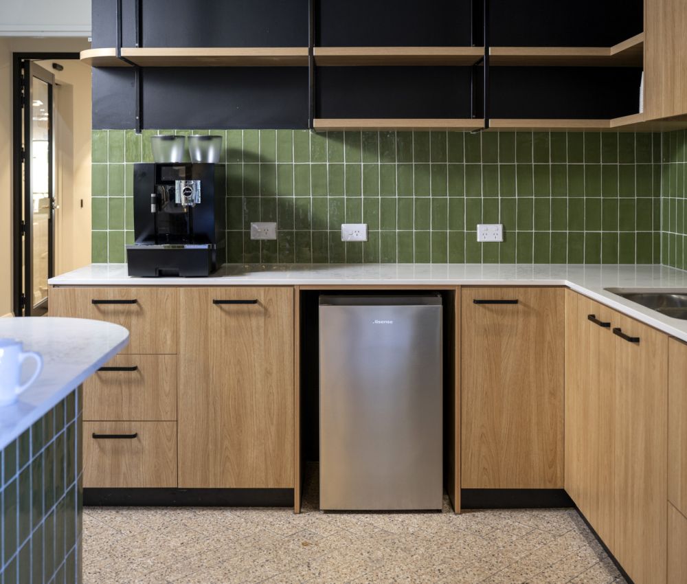 A cozy cafe area at Eldercare Goodwood aged care site, featuring tables and chairs by a large window for natural light.