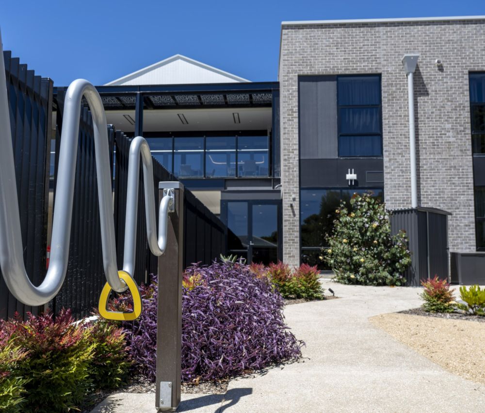 Eldercare Goodwood aged care site garden showcasing a building, fence, and outdoor gym equipment for residents' fitness.