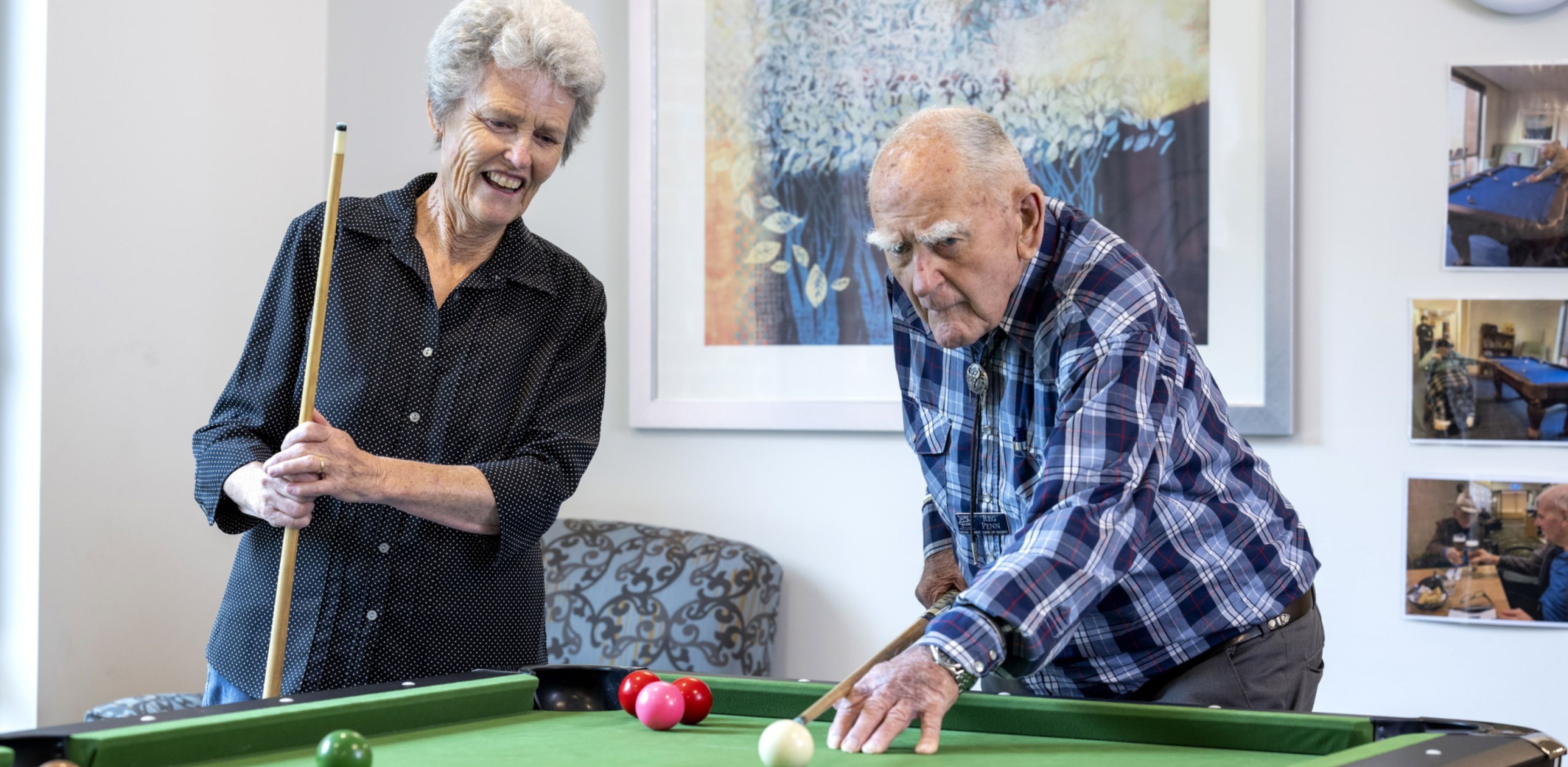 An Eldercare resident and a woman playing pool together.
