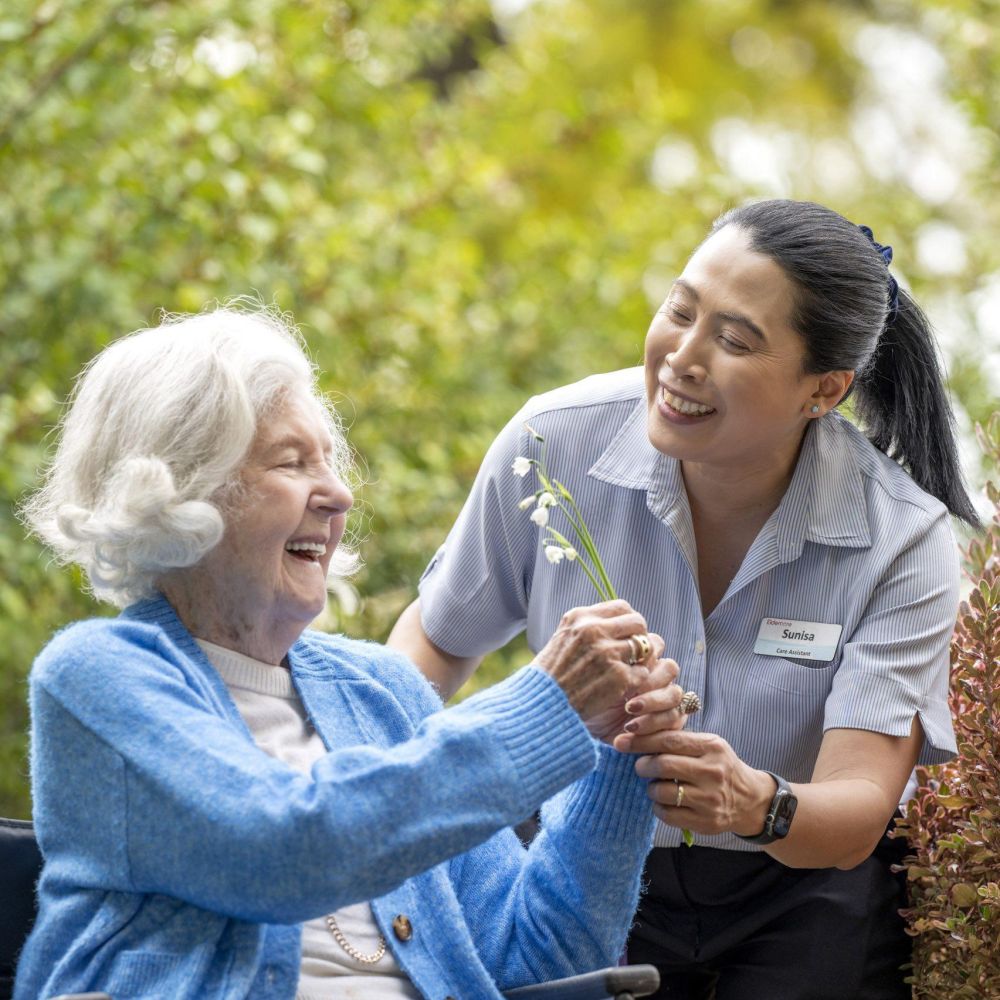Eldercare resident and staff member in the garden.