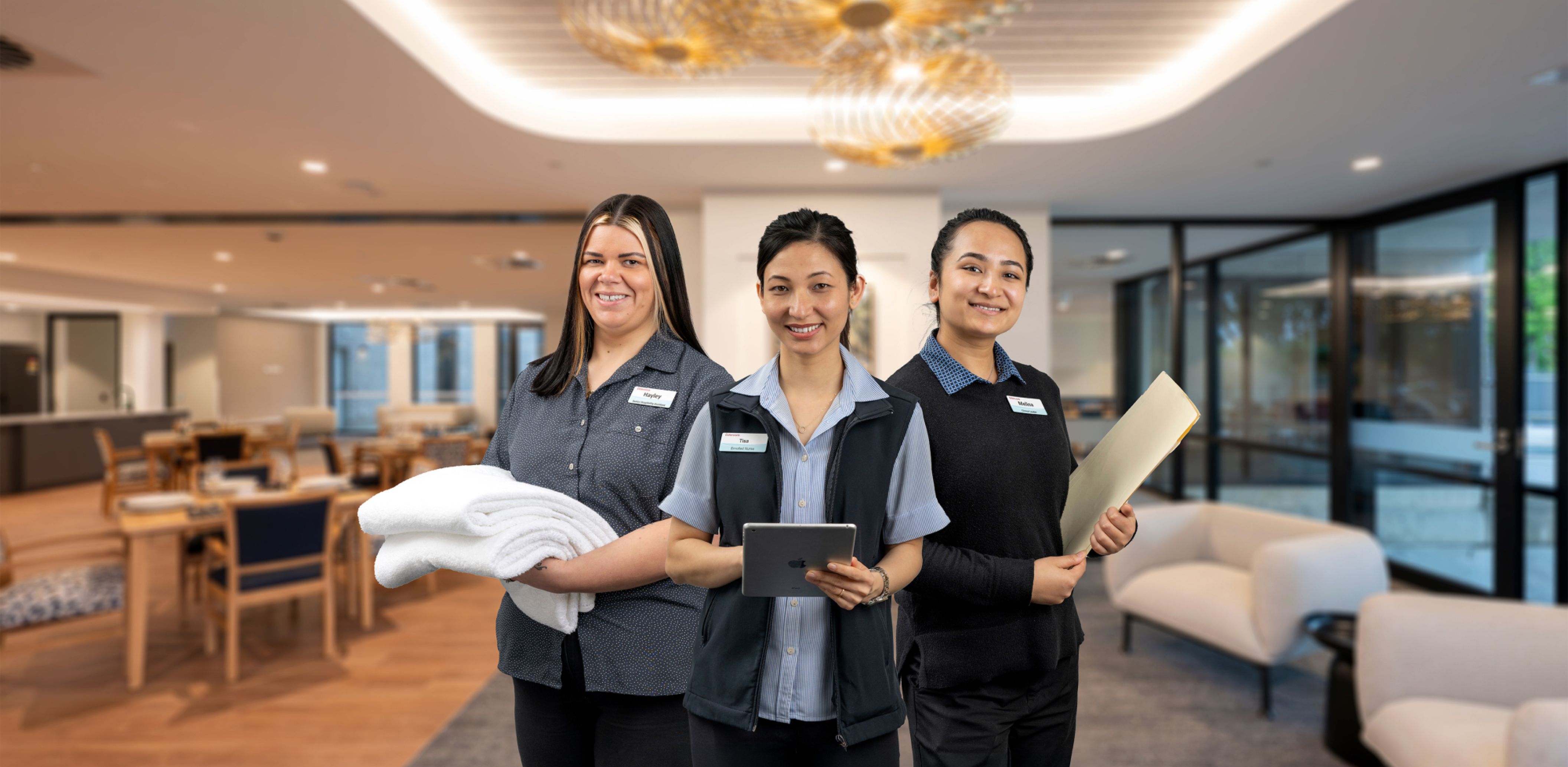 Three Eldercare staff members smiling at the camera.