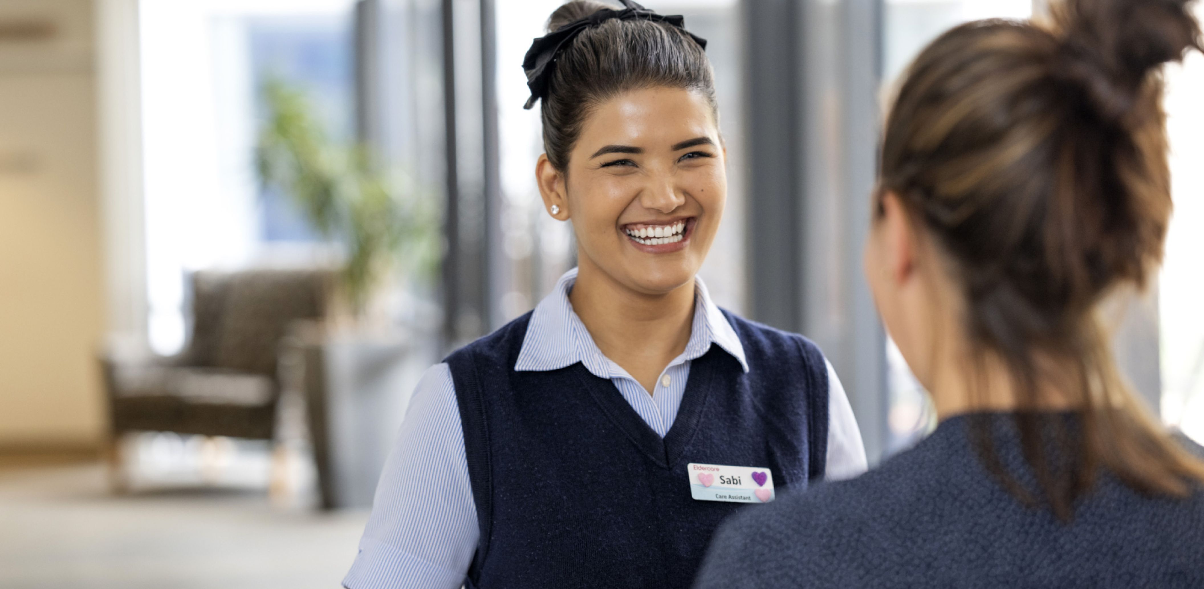 Two Eldercare staff members talking in a professional setting.