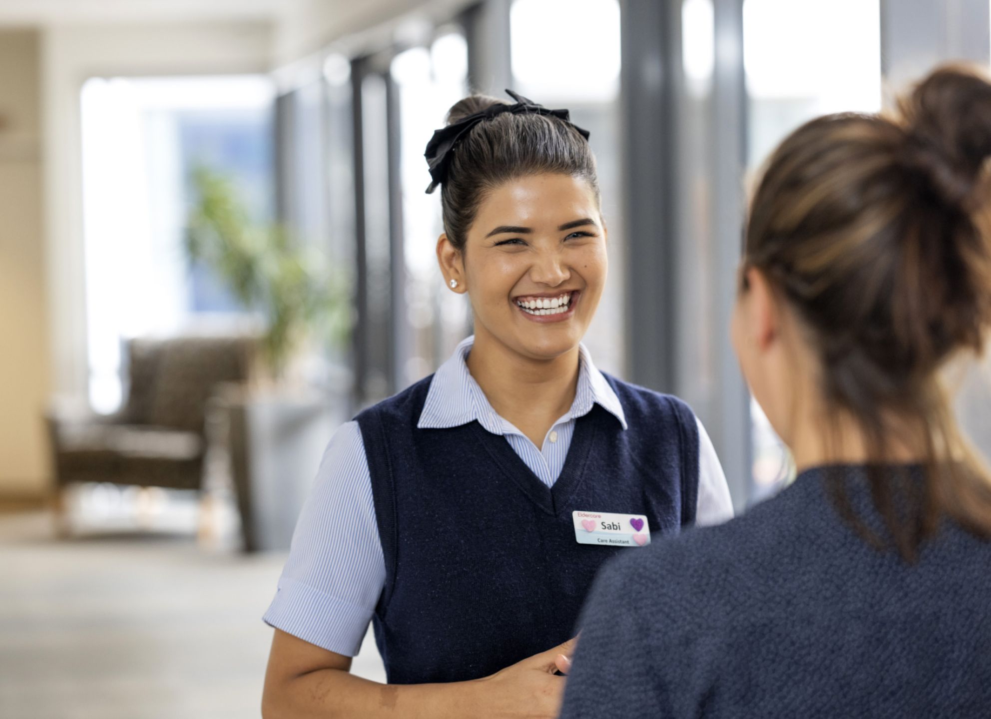 Two Eldercare staff members talking in a professional setting.