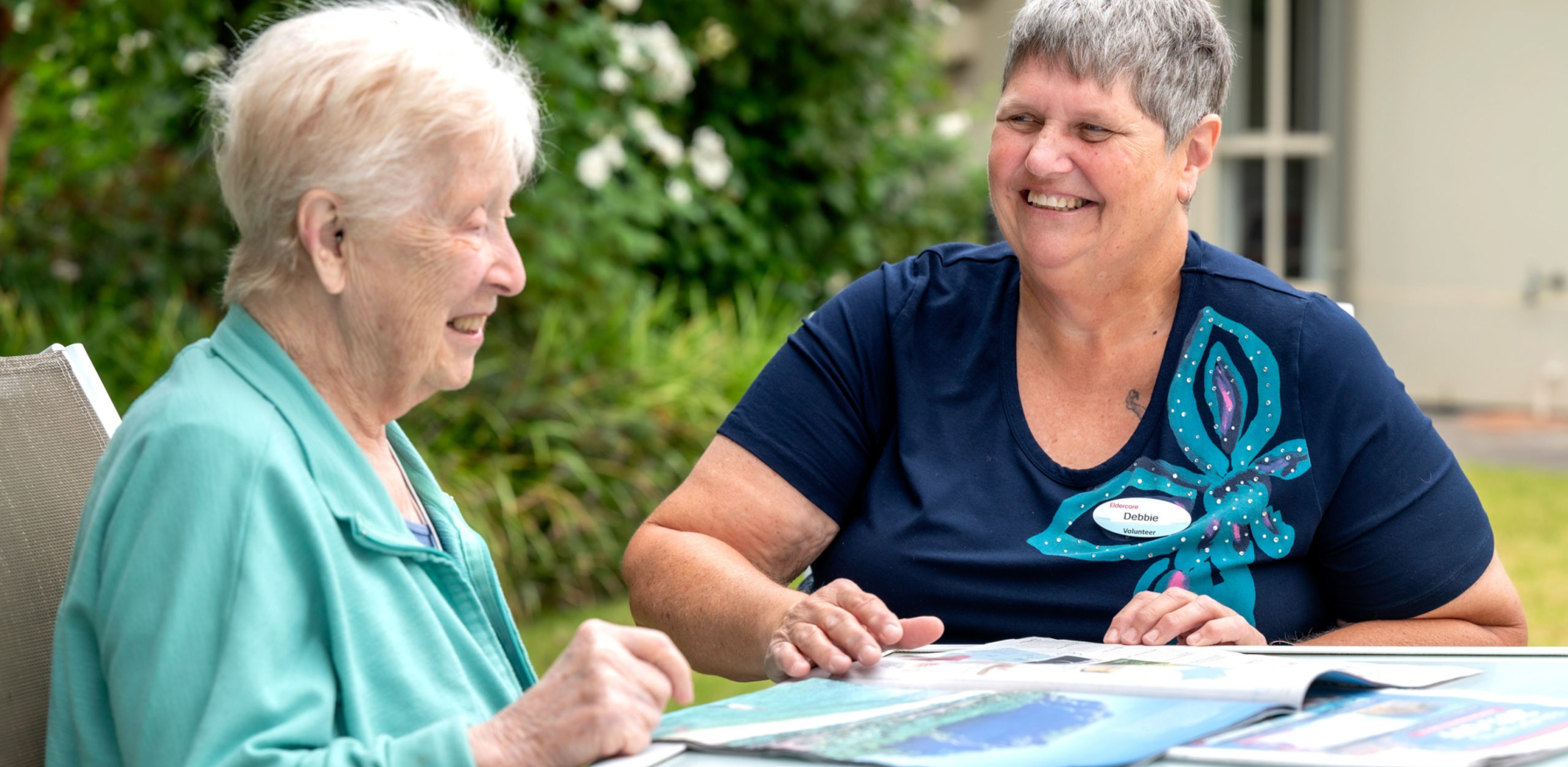Eldercare volunteer smiling with a resident.