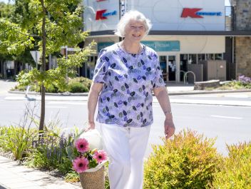 Eldercare Elmwood Grove Retirement Living resident walking and smiling.