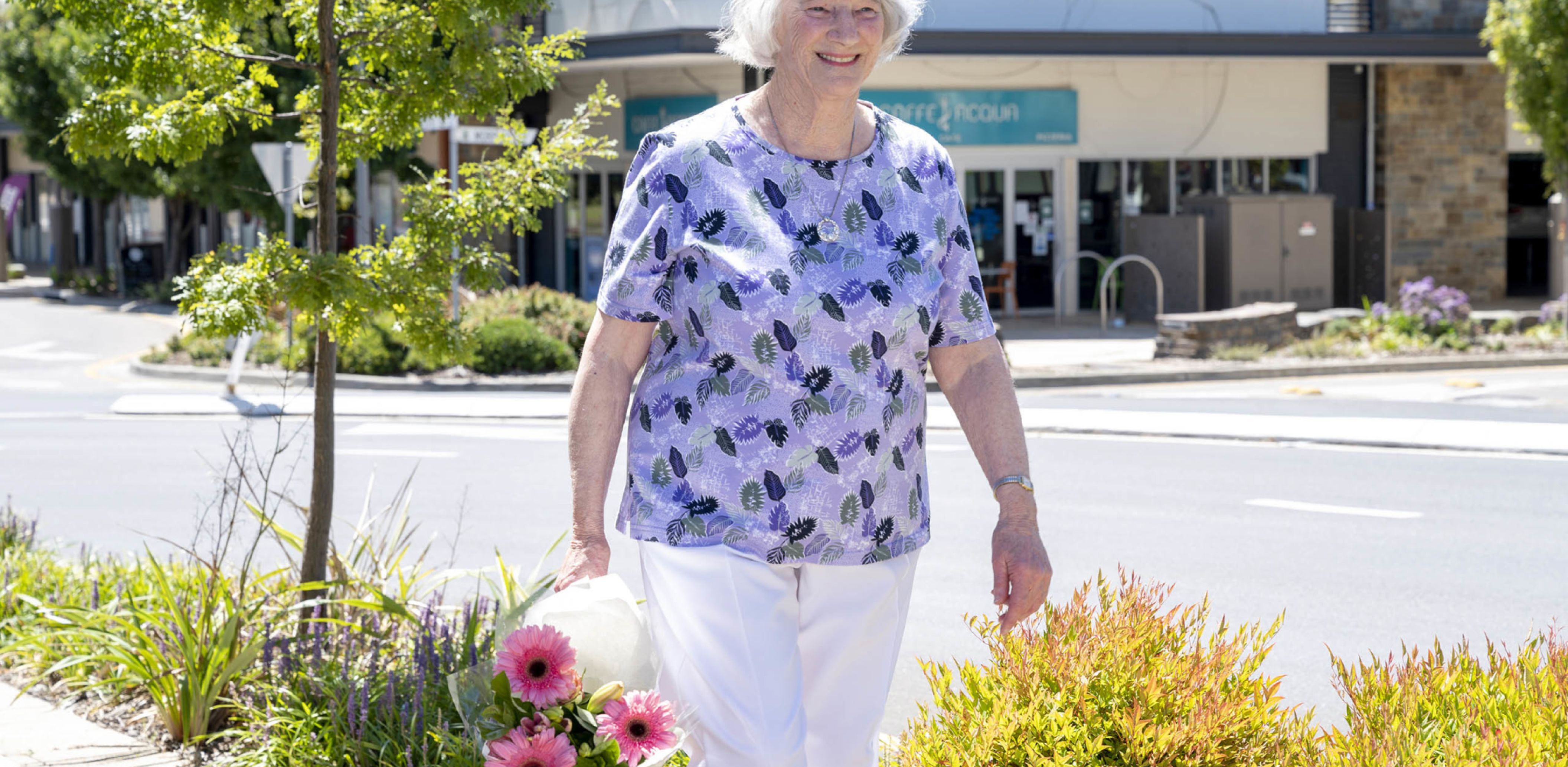 Eldercare Elmwood Grove Retirement Living resident walking and smiling.