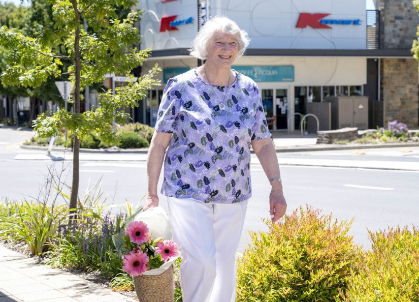 Eldercare Elmwood Grove Retirement Living resident walking and smiling.
