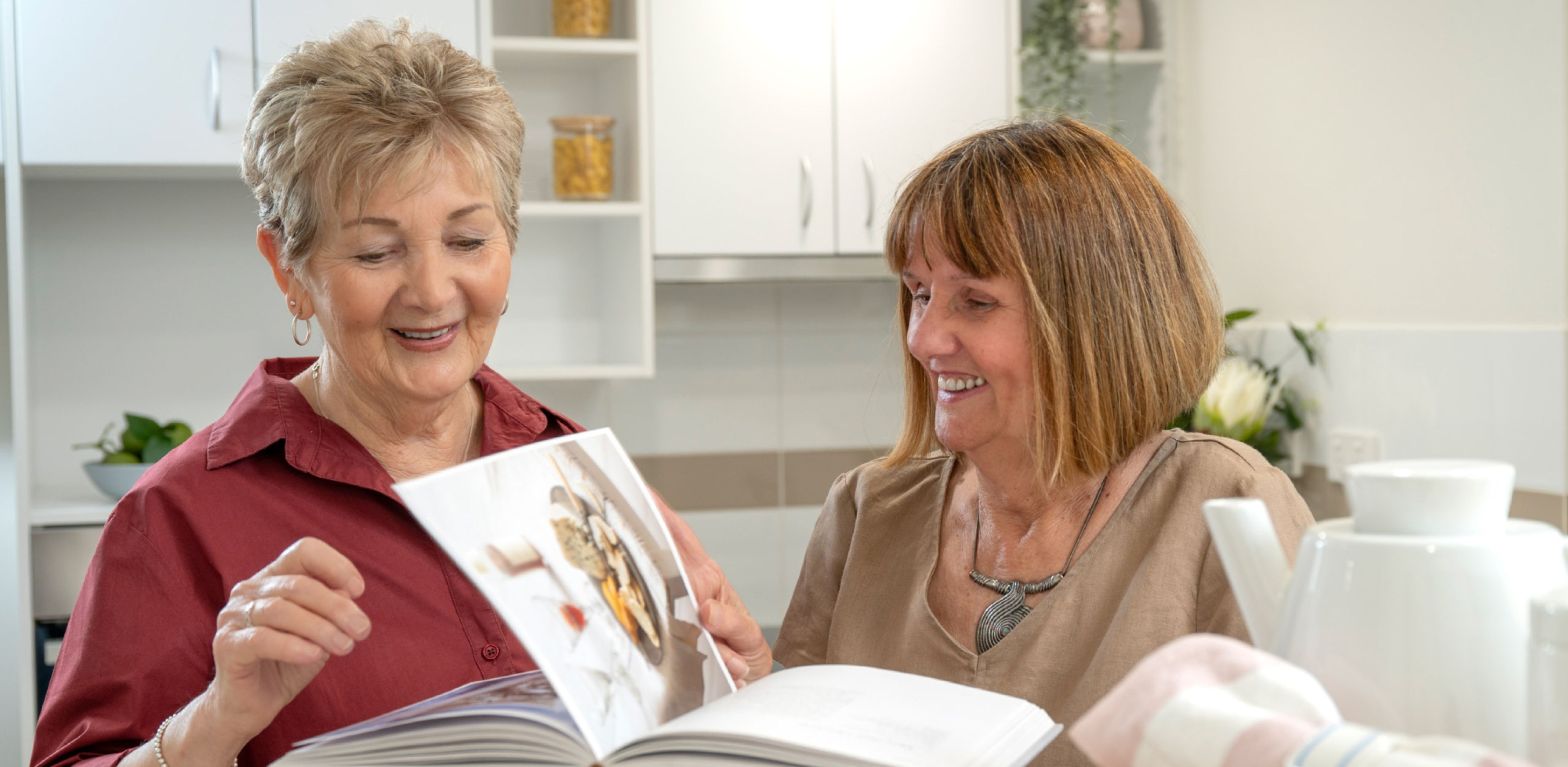 Eldercare Kingsborough Retirement Living residents reading a cooking book.