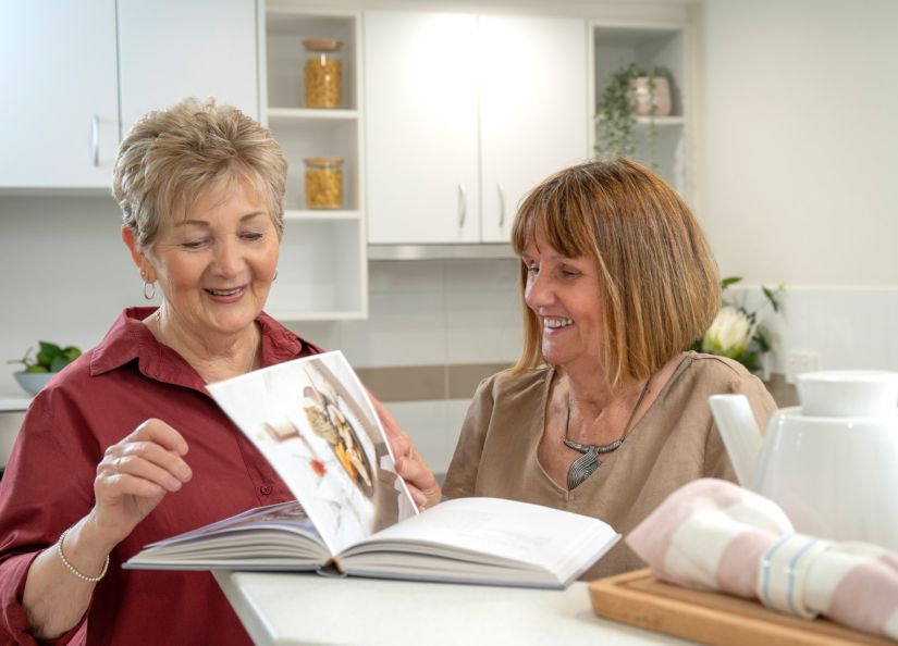Eldercare Kingsborough Retirement Living residents reading a cooking book.